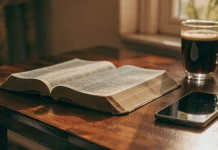 Bíblia aberta, café e celular sobre a mesa